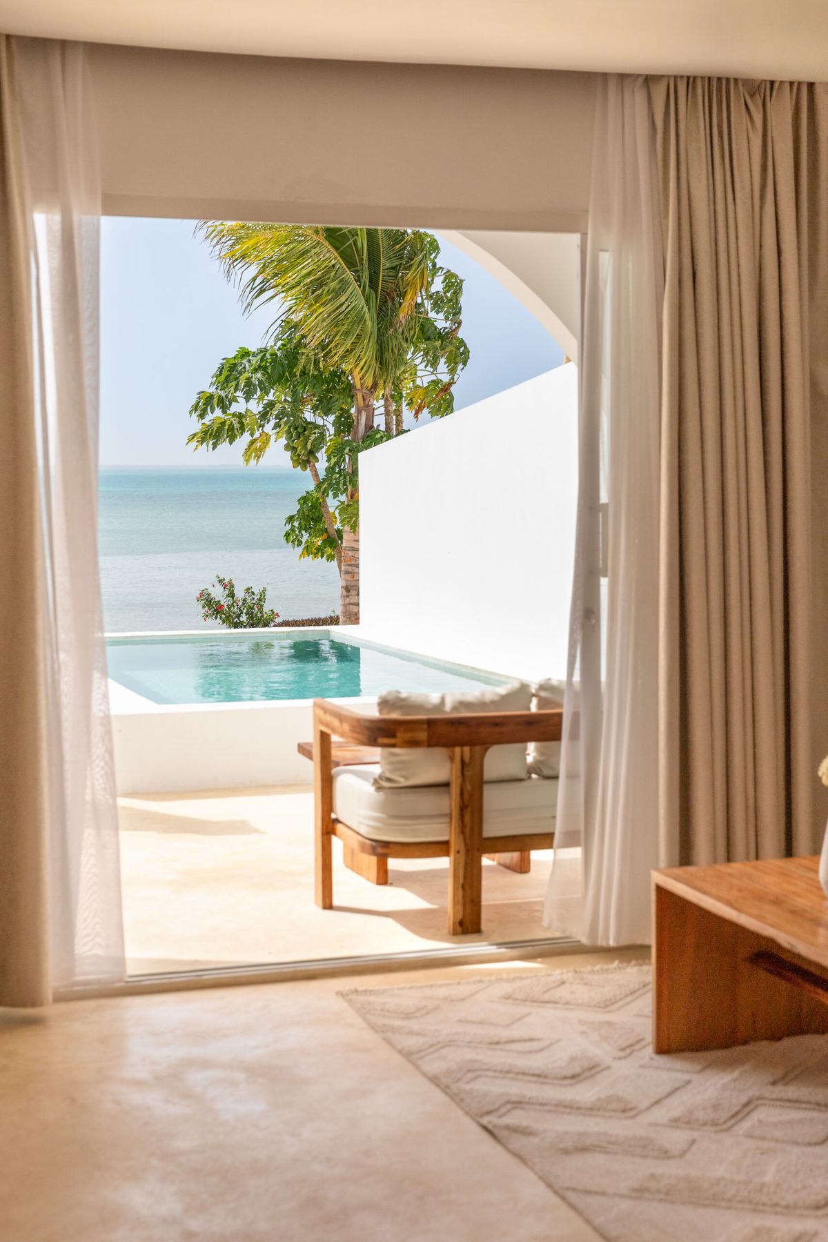 Suite terrace opening onto a private pool and the ocean beyond