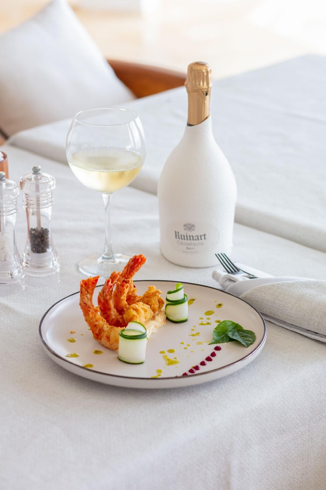 Plated prawns with white wine and champagne on a crisp white table