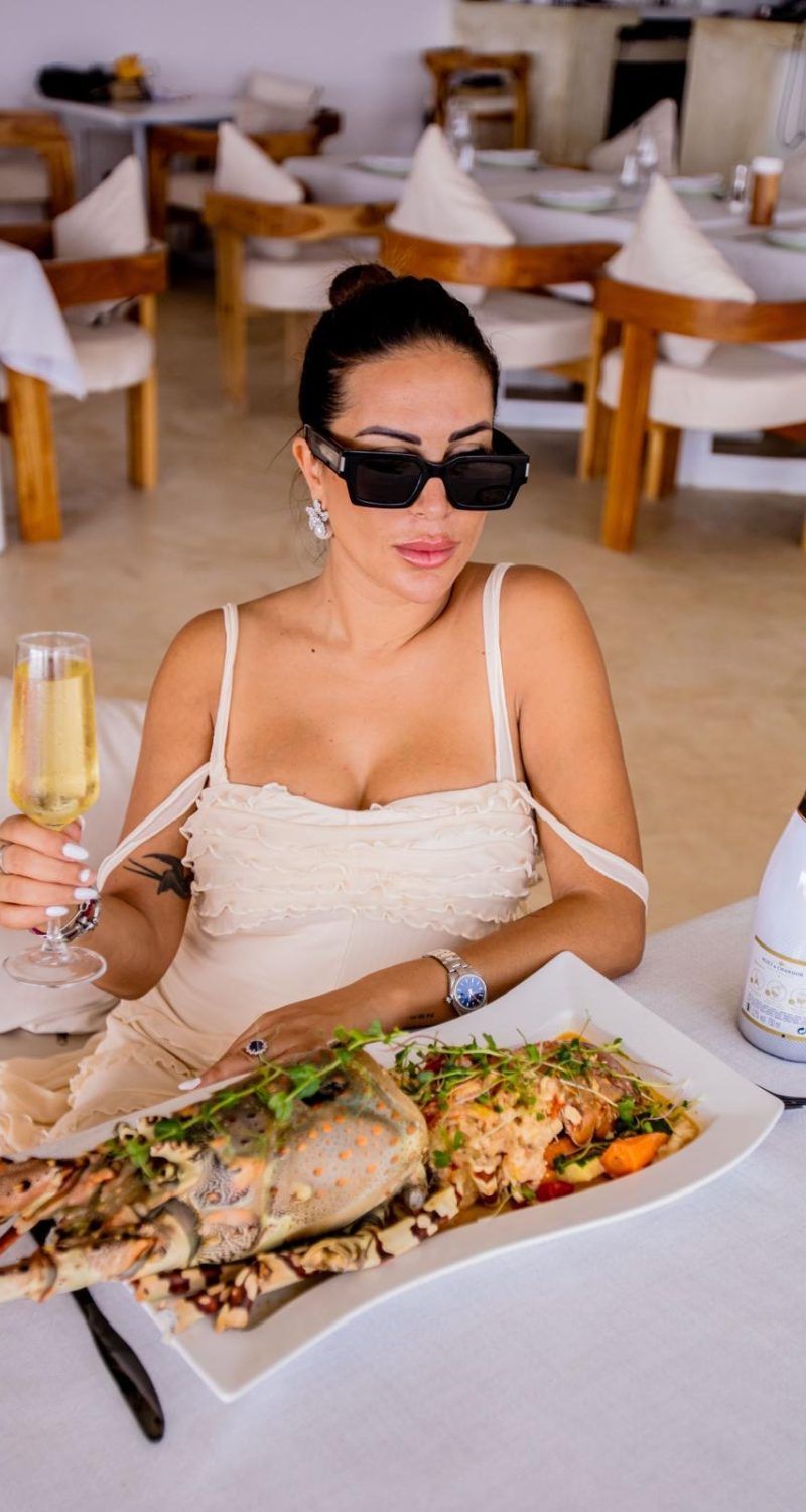 A guest enjoying grilled seafood and champagne at the French restaurant